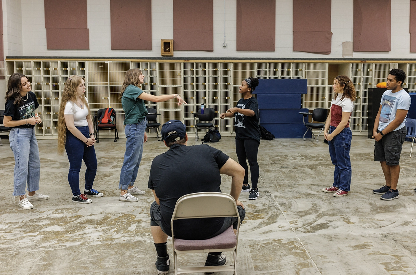 A theatre class does improv exercises in an old band classroom.