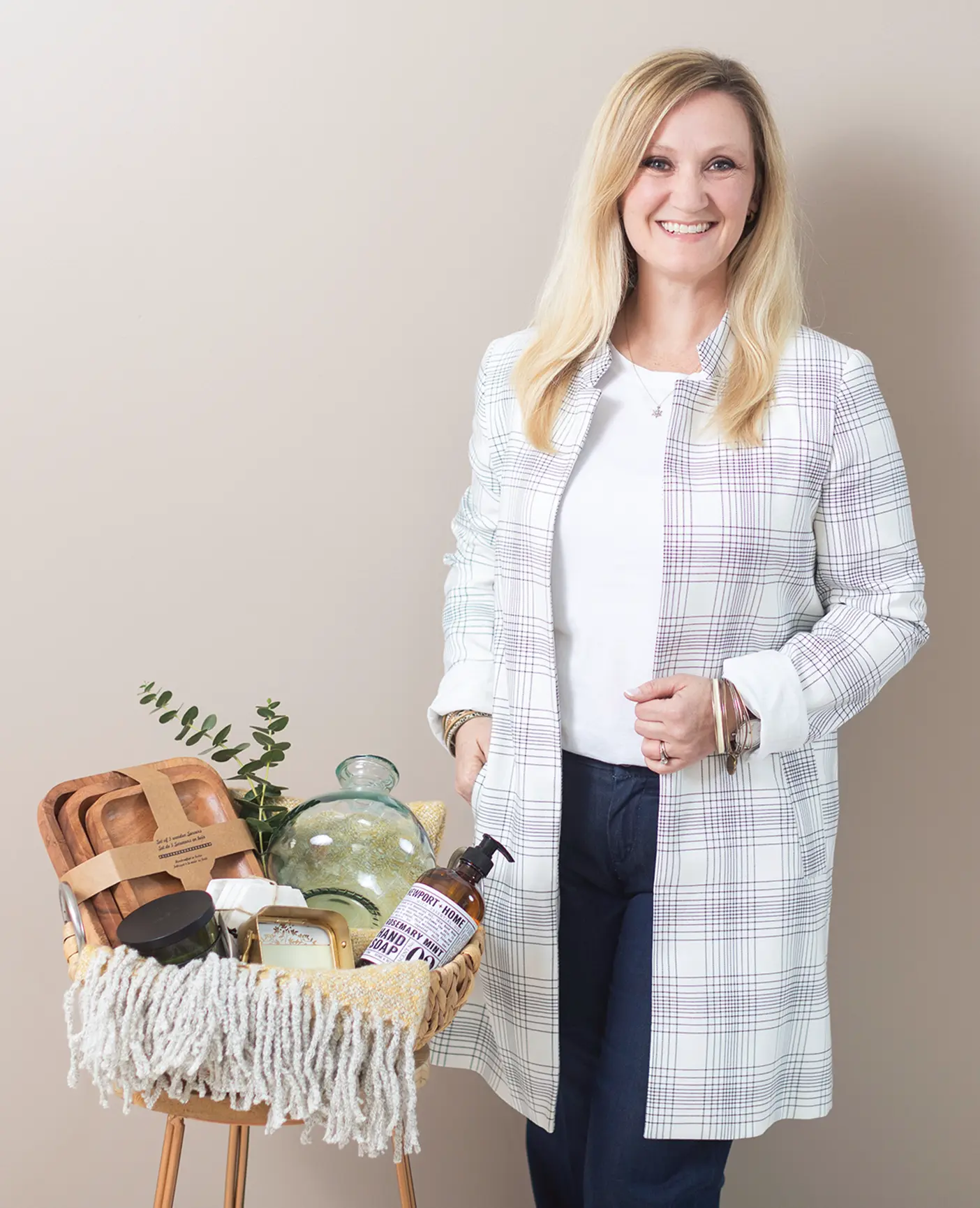 Britney Wood, a female entrepreneur, poses with a custom gift basket that she made as part of her small business.