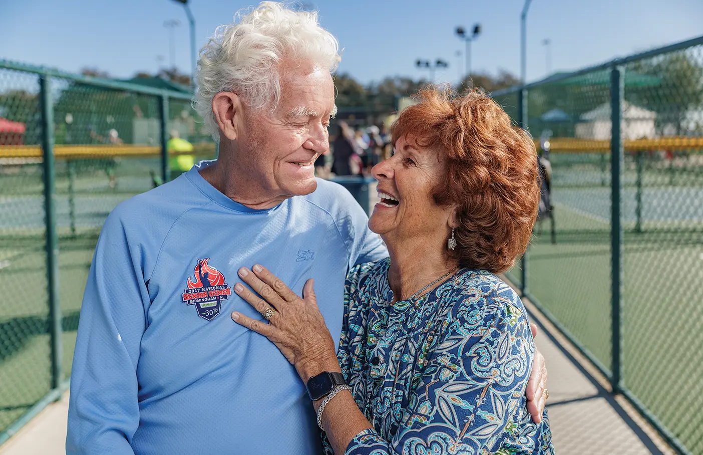 Richard E. Johnson and his wife, Lawana, embrace outside a pickle ball court.