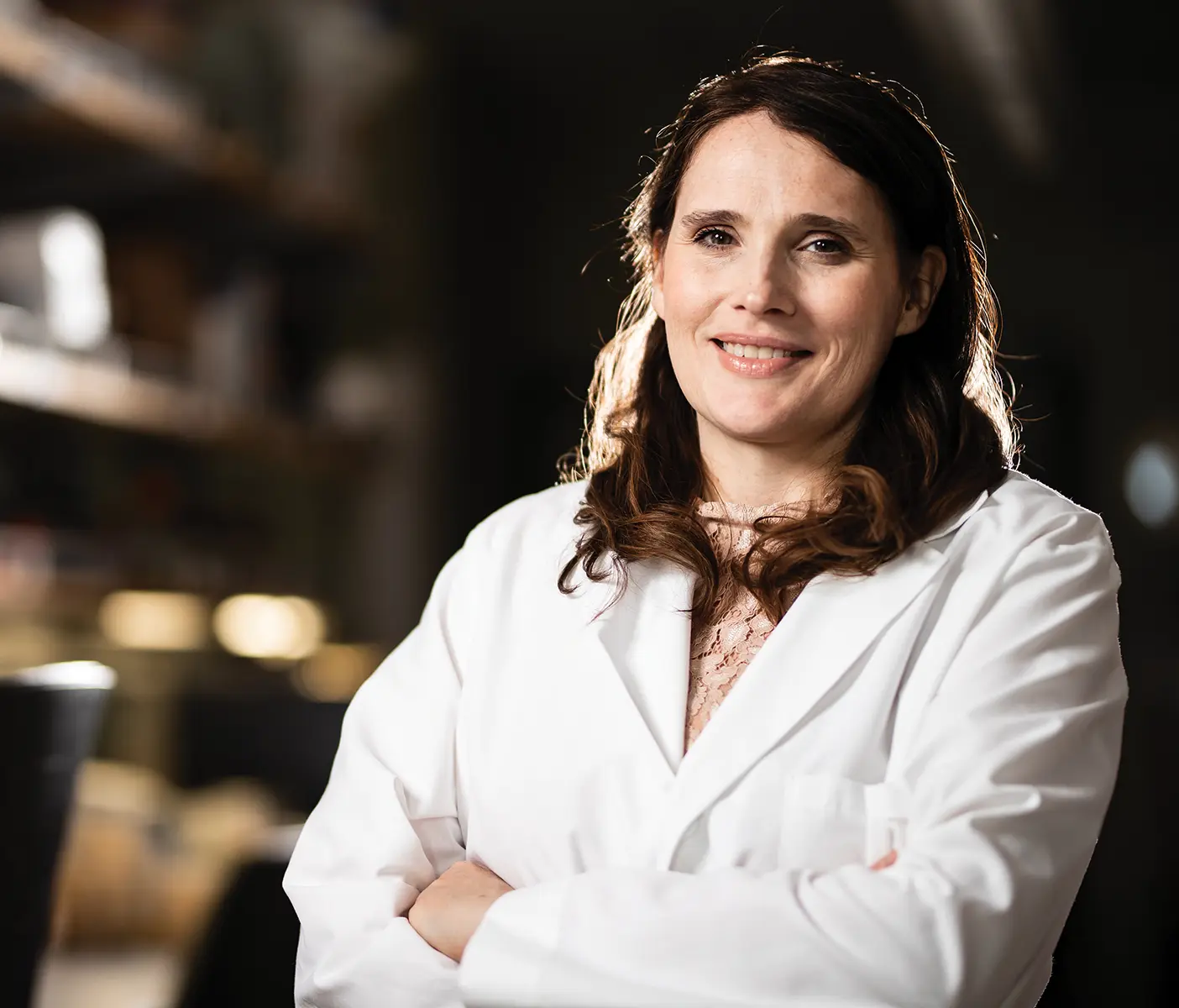 Professor Julianne Grose poses in a lab coat.