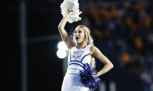 Paige Moore held up in the air, cheering as a team flyer.