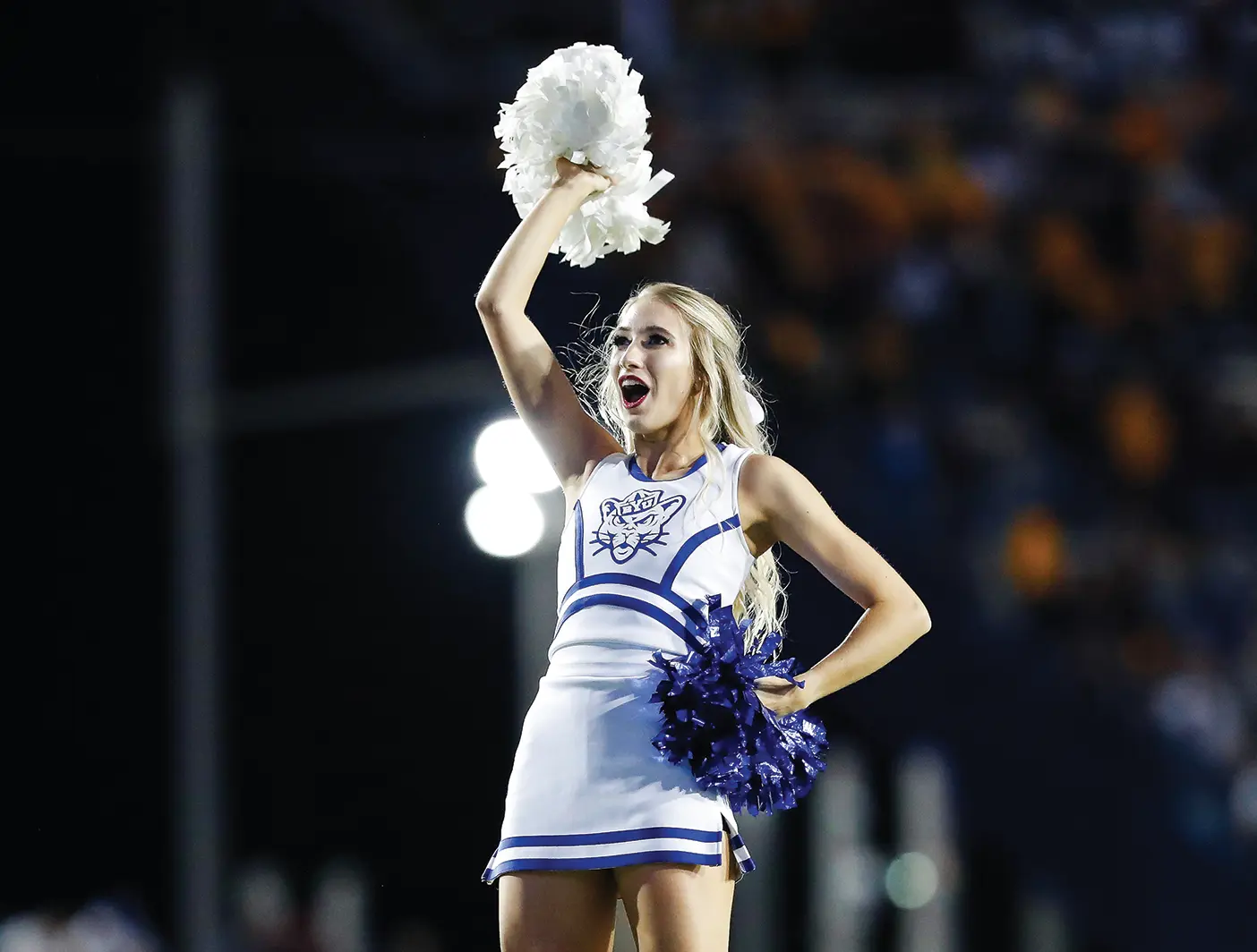 Paige Moore held up in the air, cheering as a team flyer.