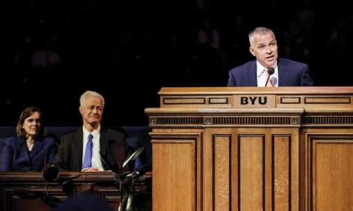 President and Peggy Worthen look on as Shane Reese addresses an audience in the Marriott Center.