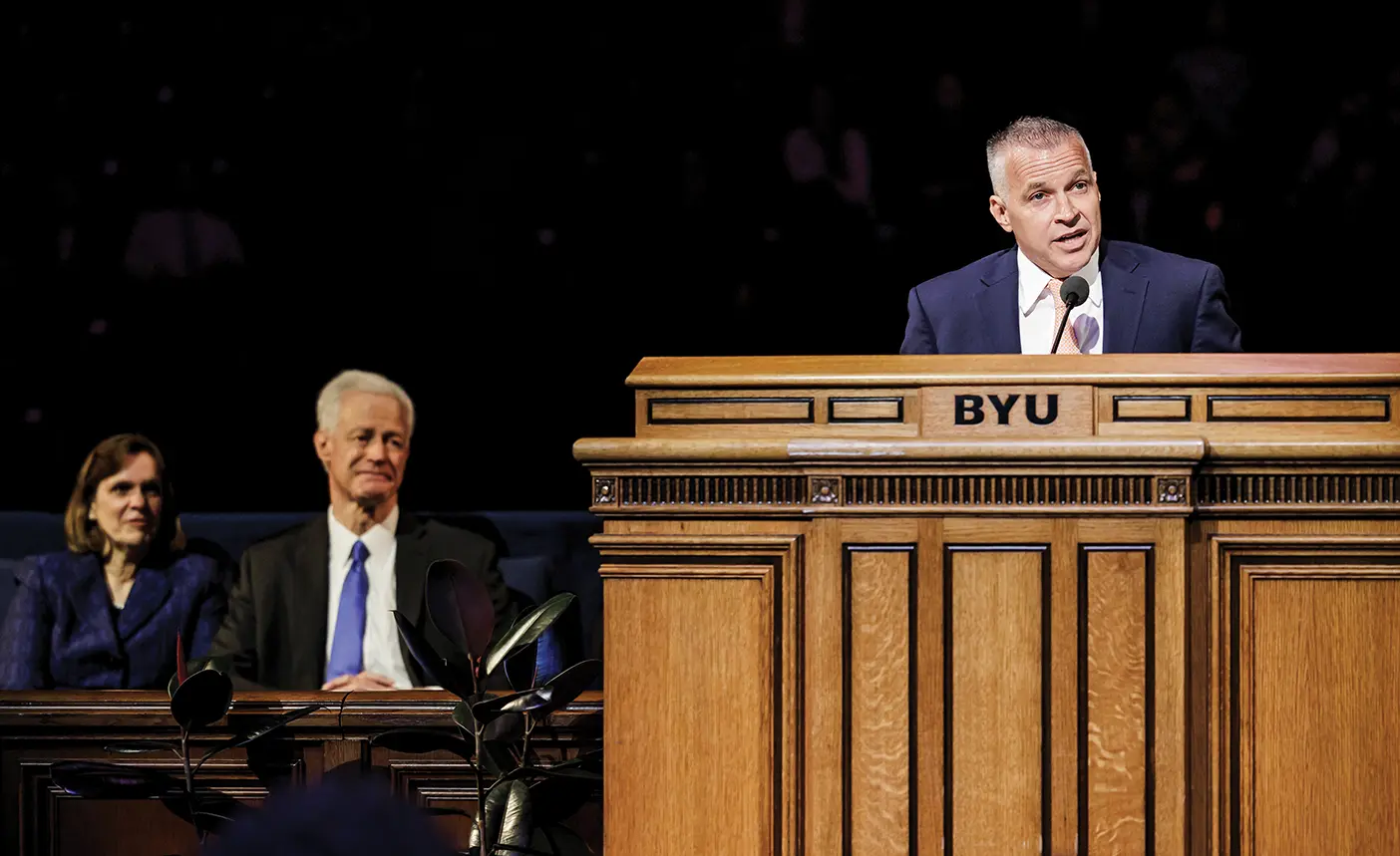 President and Peggy Worthen look on as Shane Reese addresses an audience in the Marriott Center.