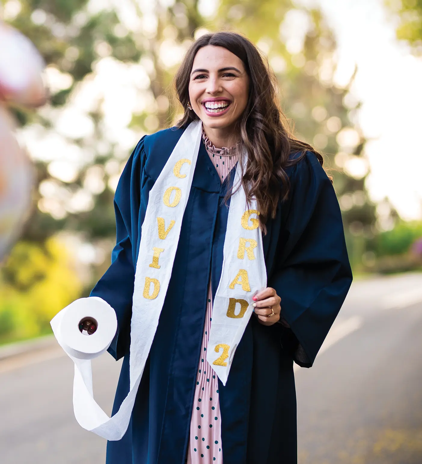 A BYU graduate in 2020 holding a roll of toilet paper.