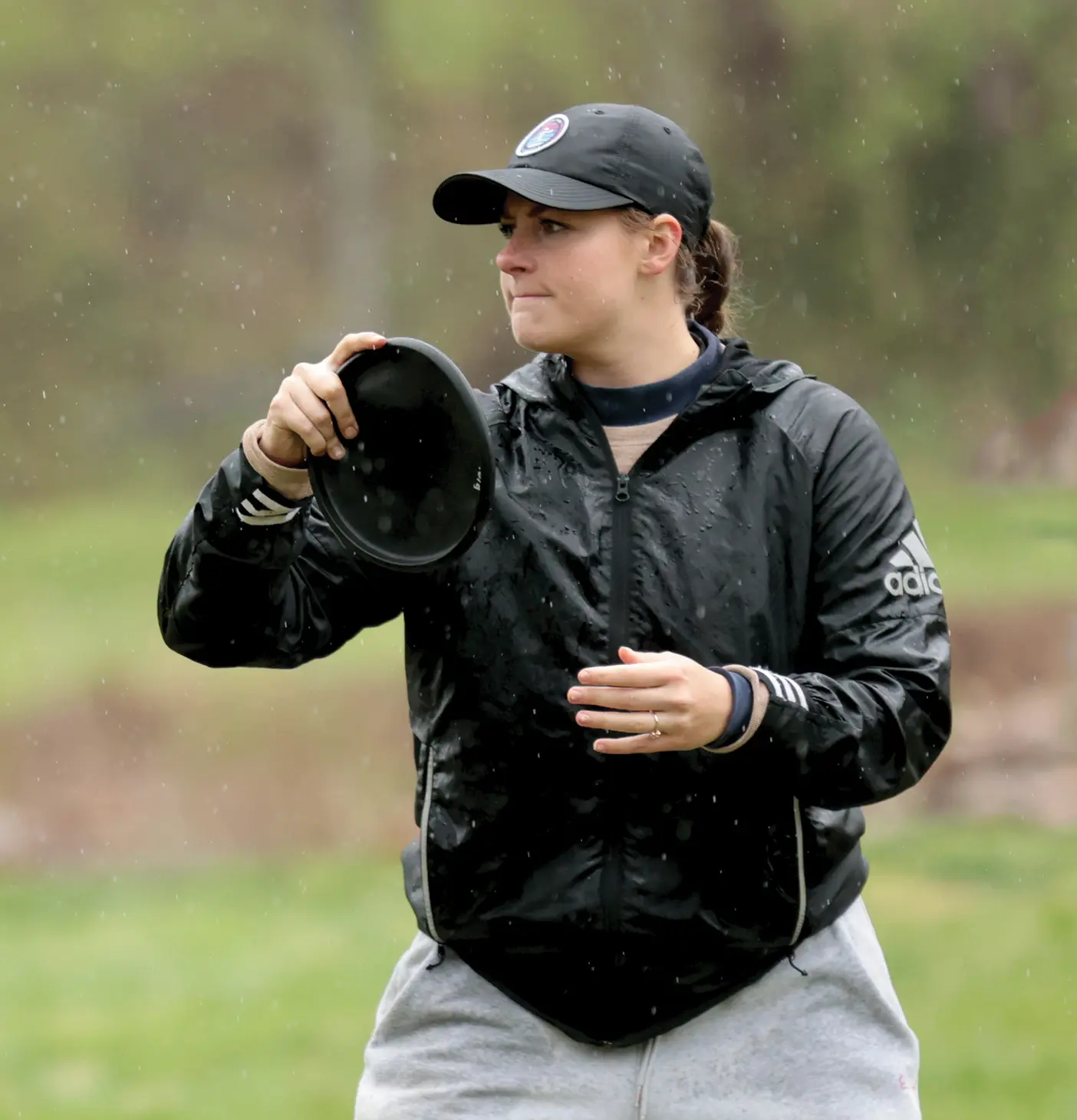 Tailey Rowley, national collegiate disc golf champion, prepares for a toss in the rain