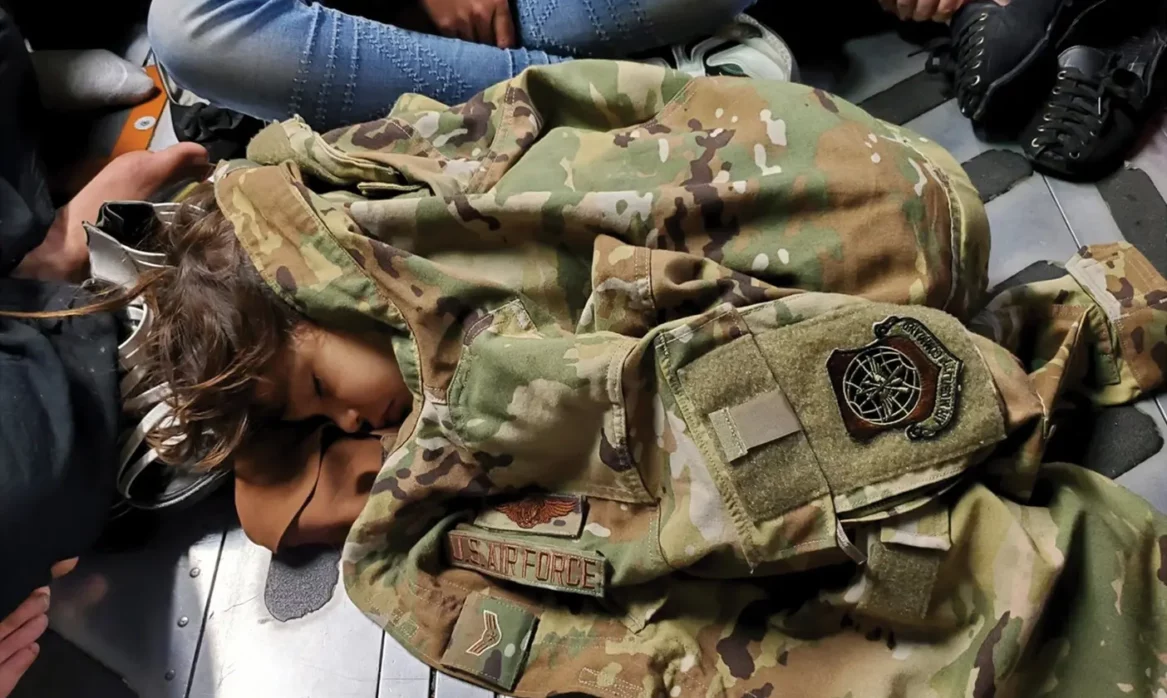 Child sleeping in US Air Force jacket.