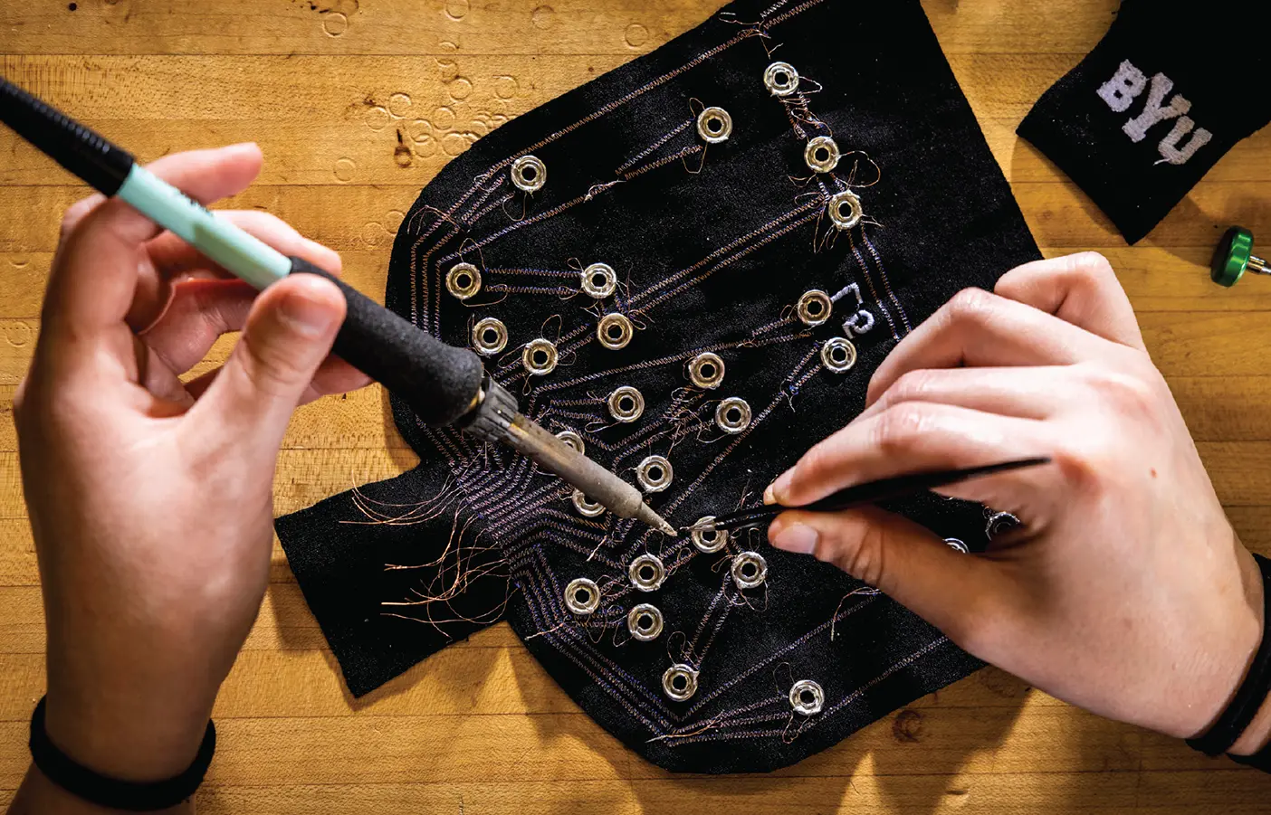 A BYU student works on circuitry with specialized tools.