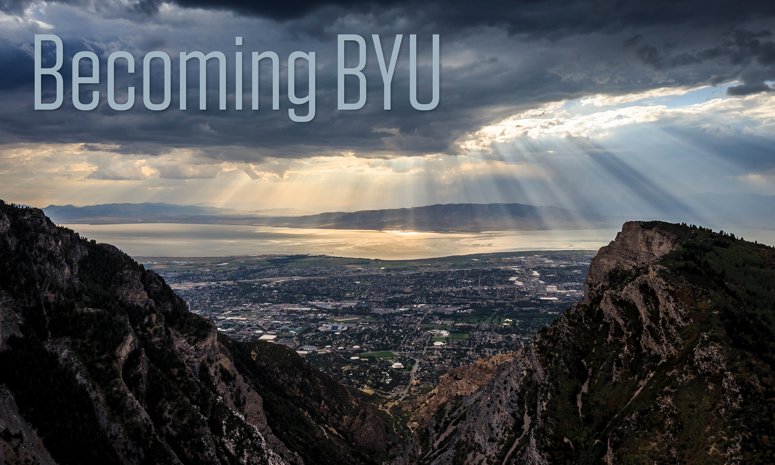 A view of Utah Valley from Rock Canyon, with light streaming down from clouds. The words Becoming BYU are printed near the top.