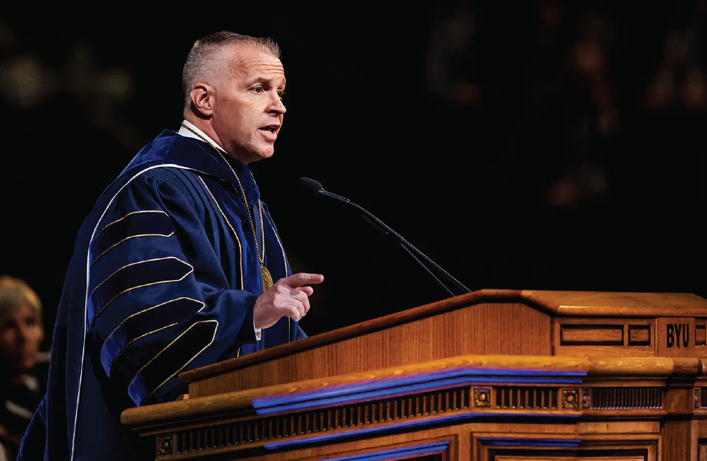 BYU president C. Shane Reese standing at a pulpit speaking at his inauguration.