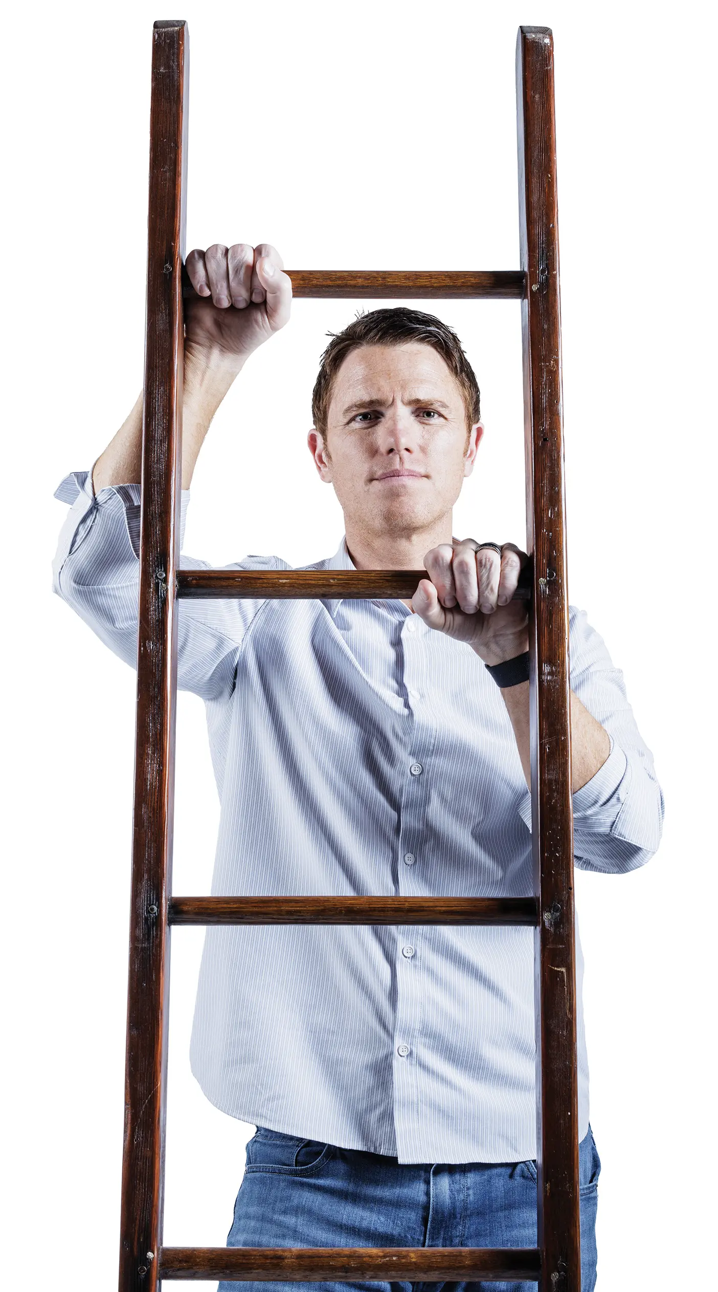 A man in a blue shirt is climbing a ladder and looking forward.