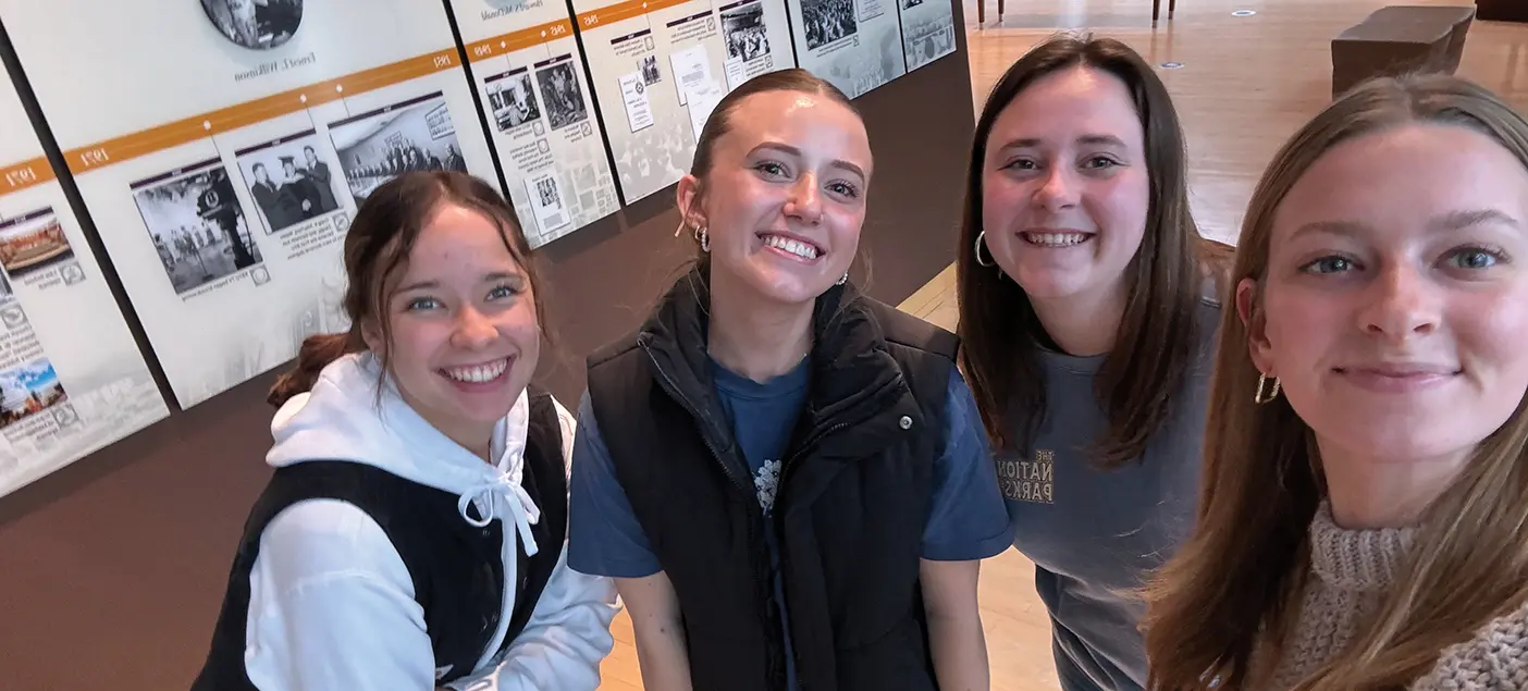 Four female BYU students at an exhibit on campus.