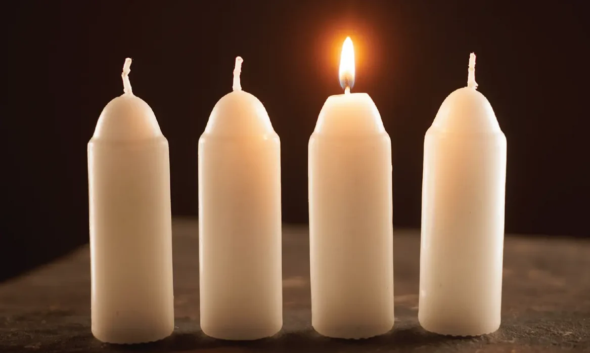 Four candles, with one lit.