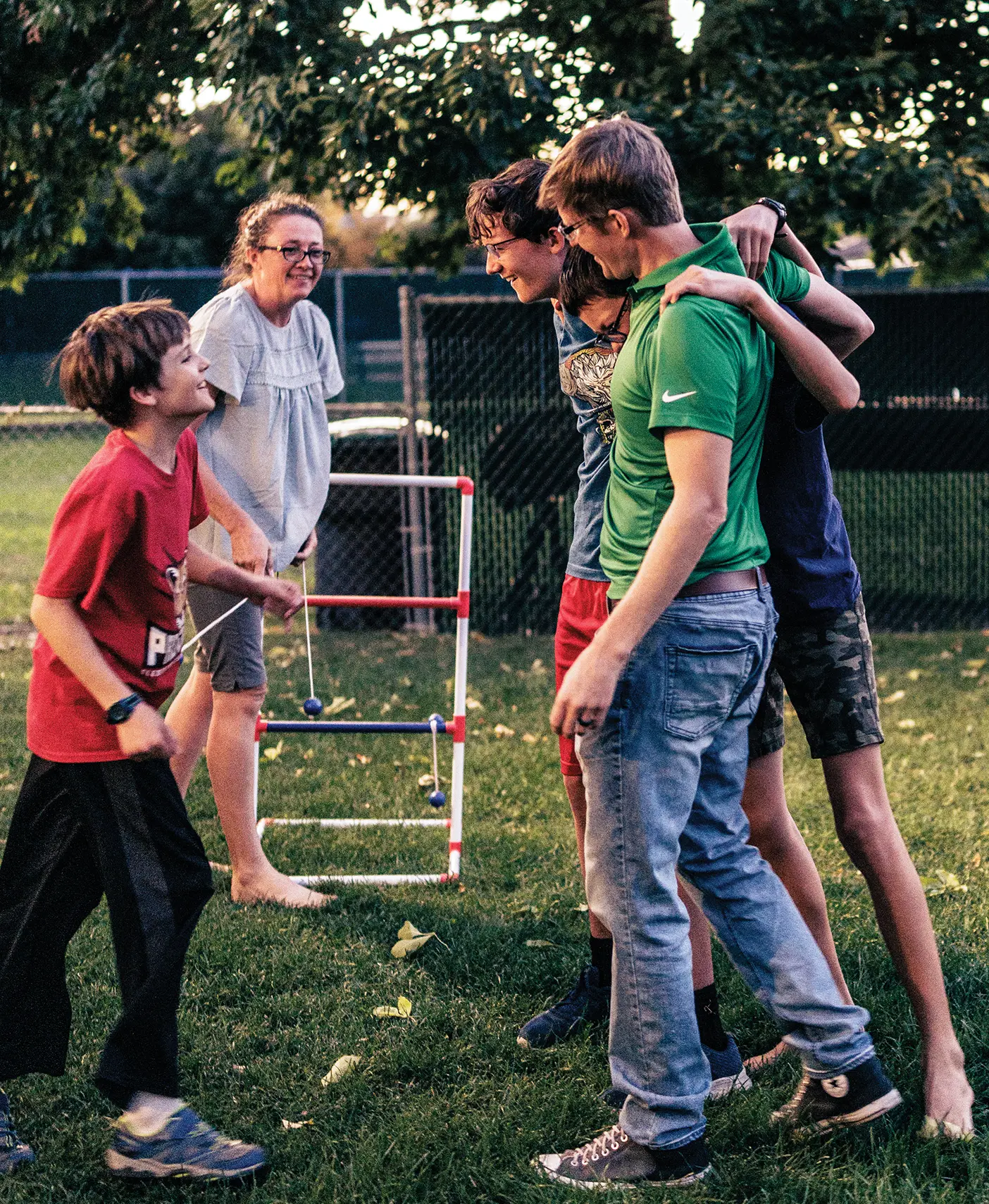 A smiling family plays an outdoor game together.