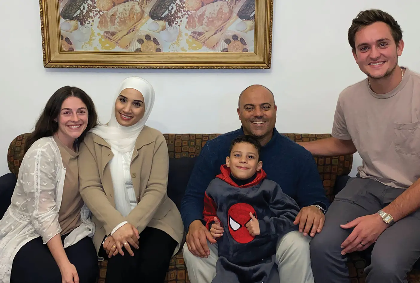 Sydney Schmidt and her husband, Spencer Shields, sit with Dilal, Ali, and their family in Jordan.