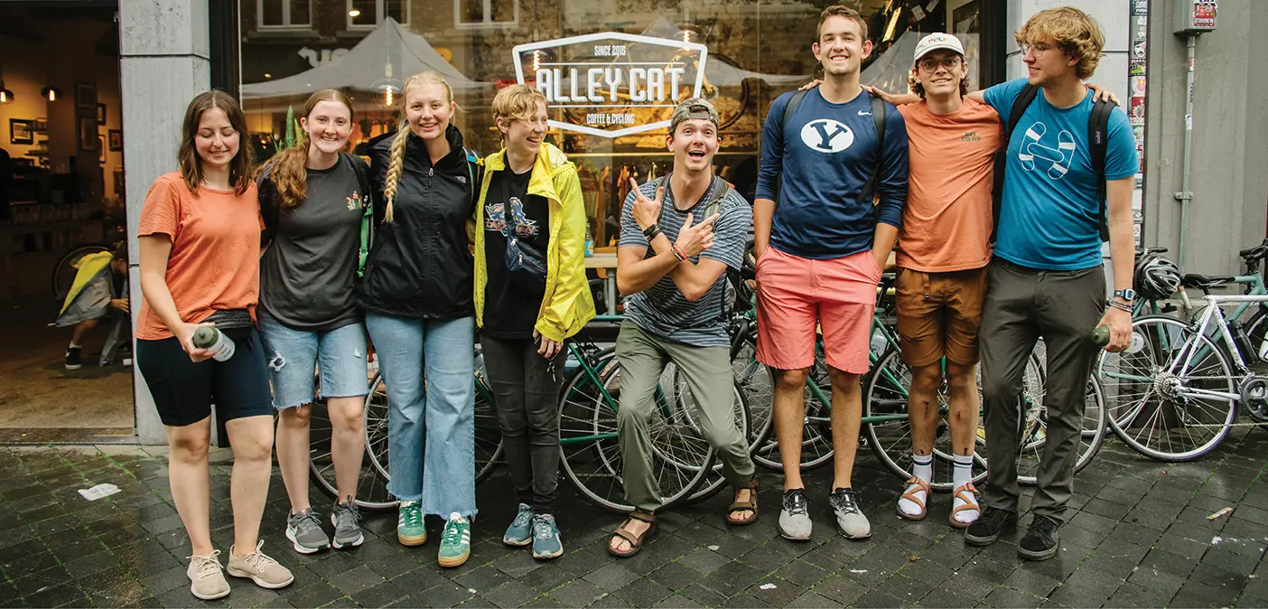 BYU students pose with their bikes outside a shop in Europe.