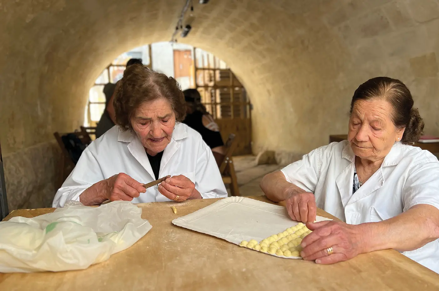 Two older women preparing food in Italy.