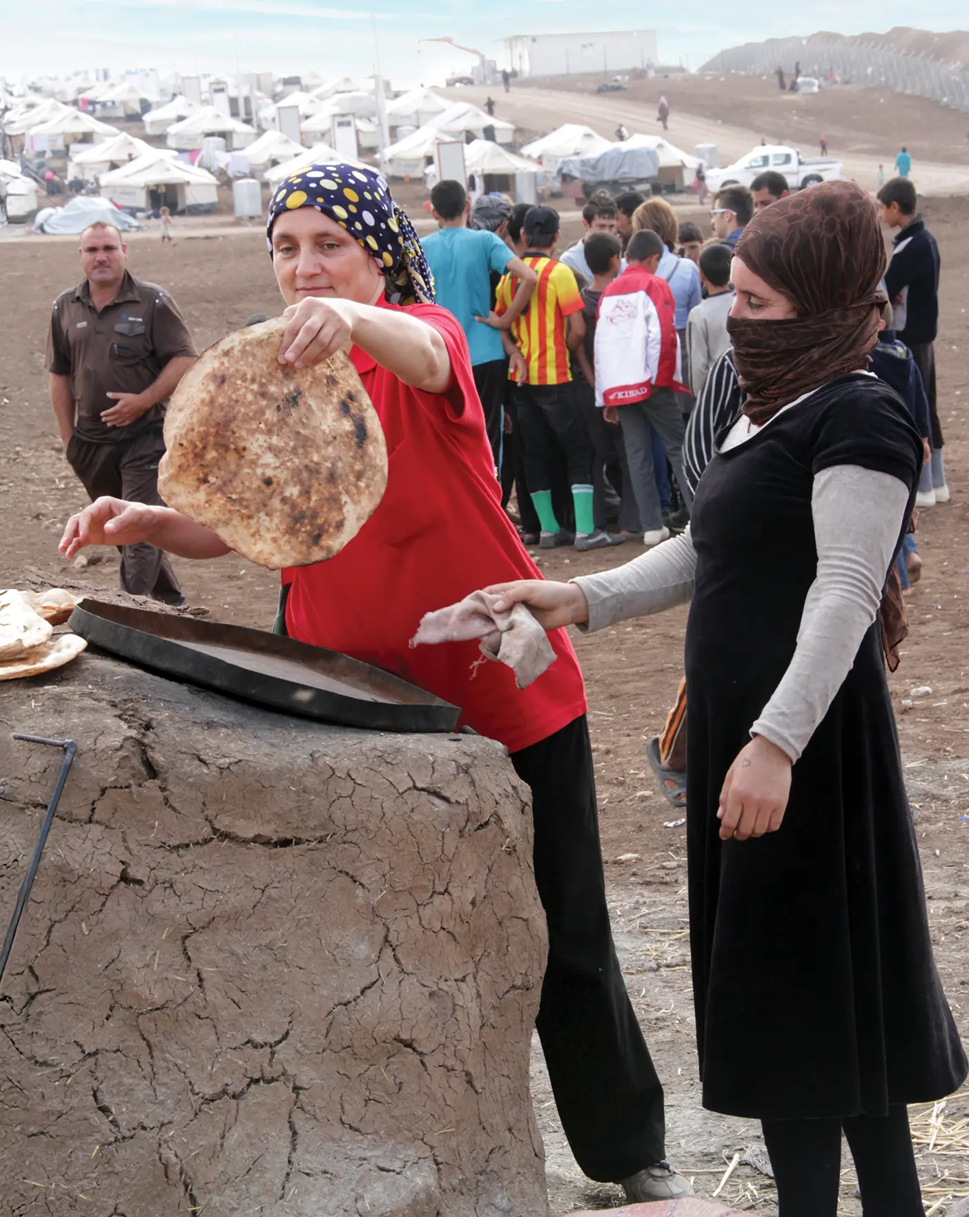 A Yazidi refugee offers bread to Sarah Jane Weaver