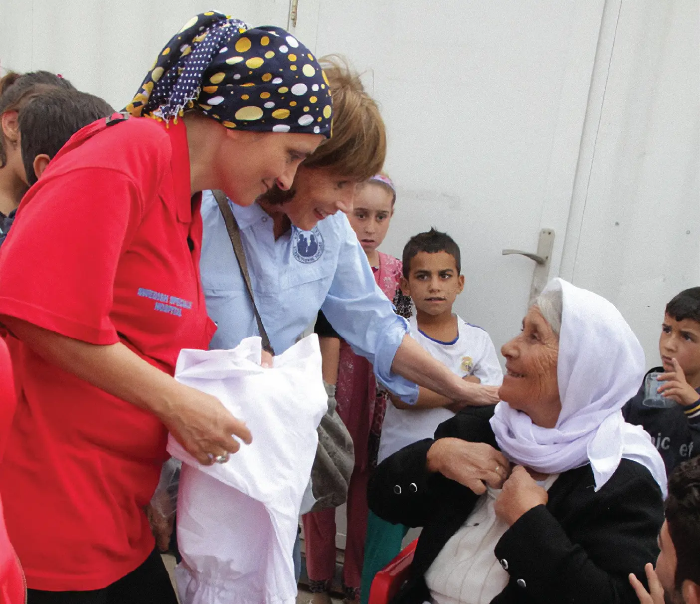 A Yazidi refugee woman receives a new white dress, religiously significant to her faith, provided by Latter-day Saint Charities in northern Iraq in 2014.