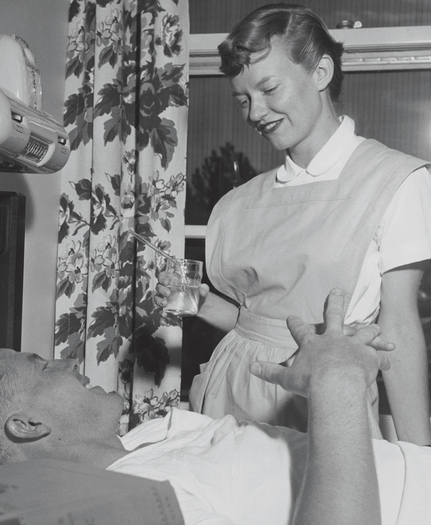 A BYU nursing student helps a patient who is lying down.