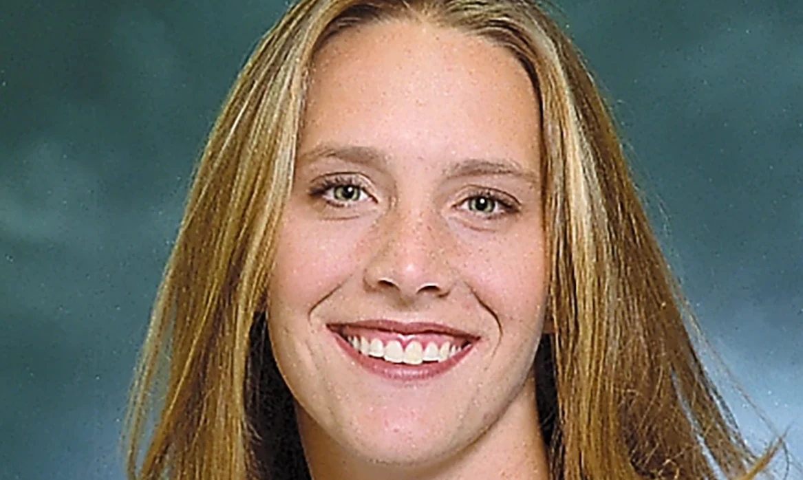 Color portrait of a smiling female volleyball player wearing a white BYU jersey.