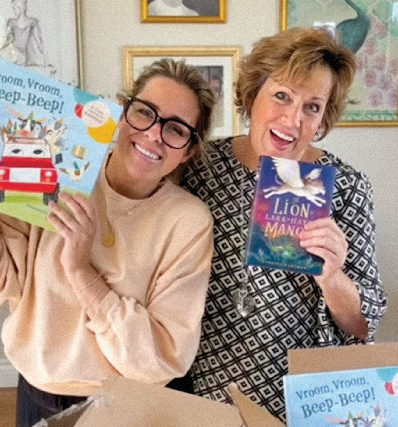 Aubrey Hartman and Lezlie Hartman pose together with each other's published books. 
