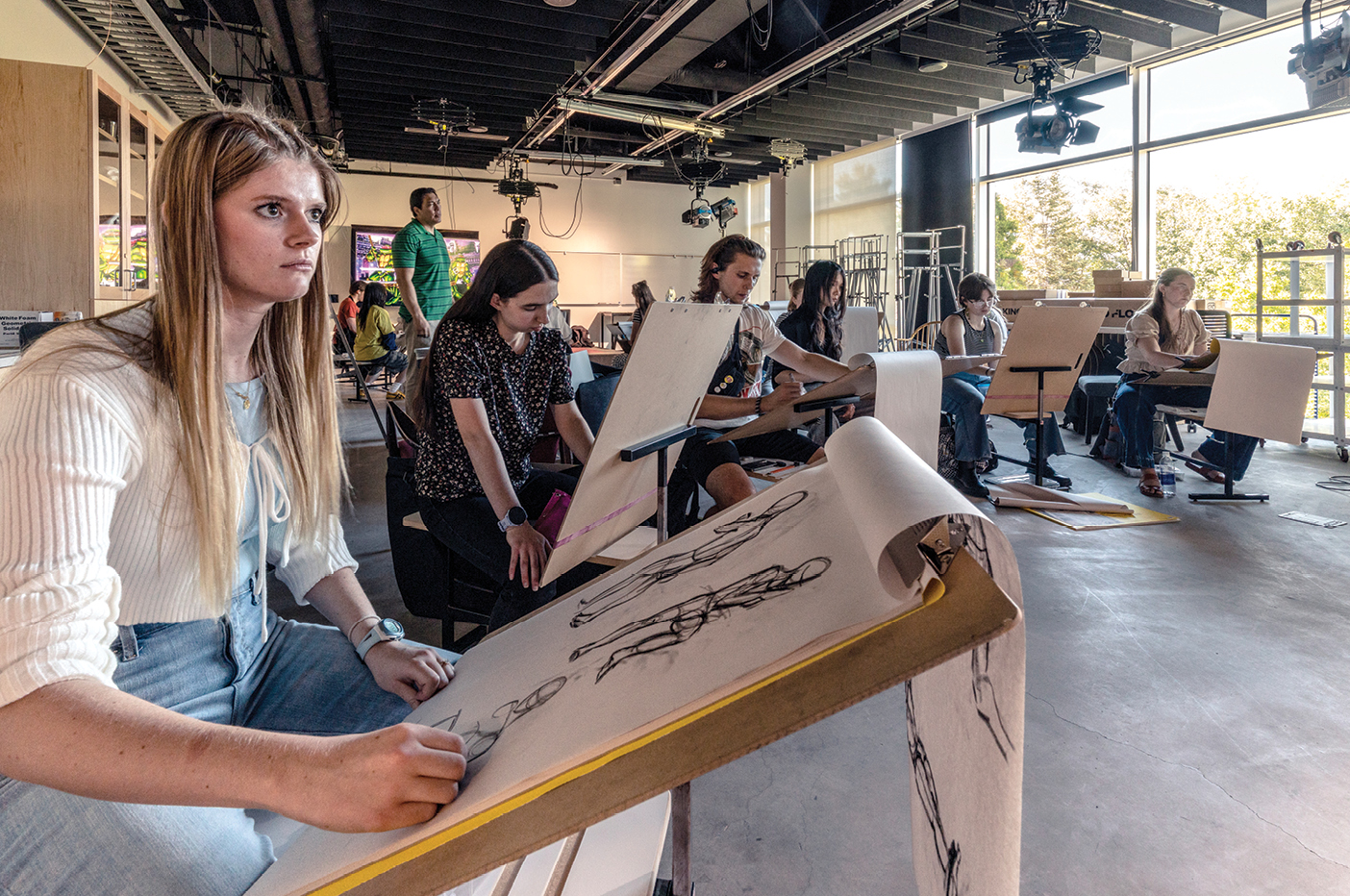 Soft northern light floods a classroom through a wall of windows, helping student artists sketch more precisely in the BYU Arts Building.