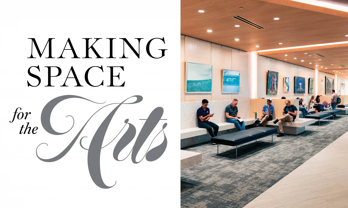 Making Space for the Arts. Students and visitors sit on pale terrazzo benches and black upholstered seating in a spacious lobby. Framed artwork lines the wood-paneled wall, while recessed ceiling lights and warm wood accents illuminate the room.