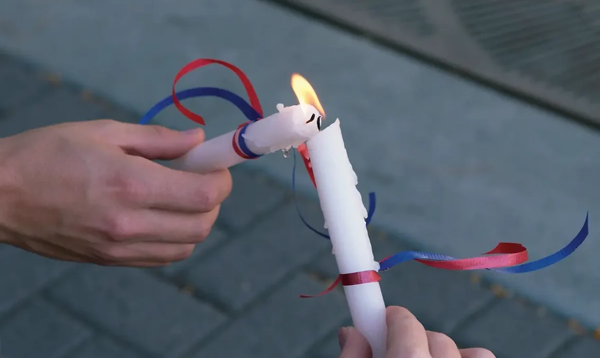 Two candles share a flame as their wicks touch during a candlelight vigil to commemorate the Sept. 11, 2001, terrorist attacks.